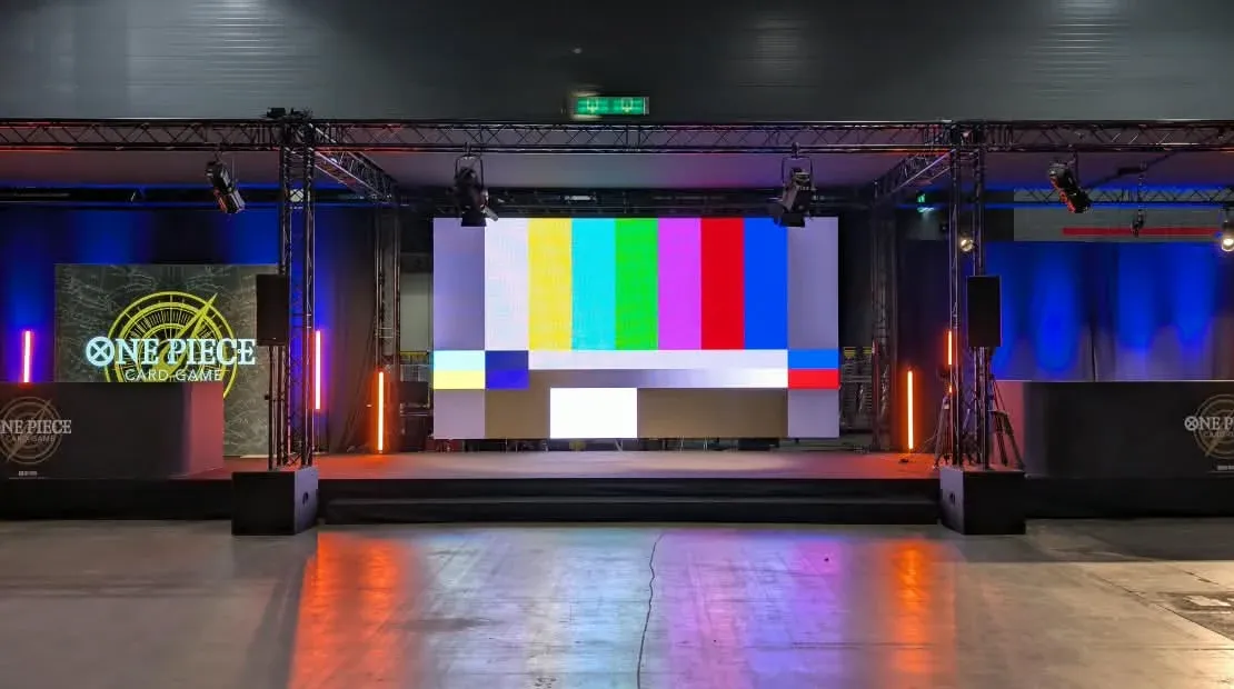 LED-Wand mit Testbild auf einer Bühne zwischen zwei Traversentürmen